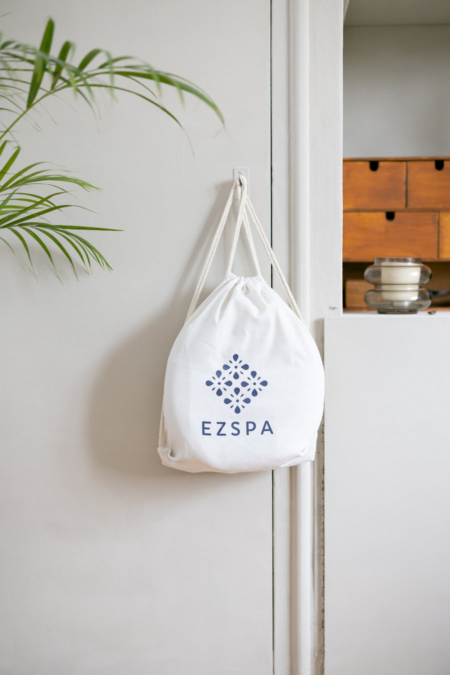 O saco de transporte de algodão da Ezspa com o logotipo, pendurado num quarto