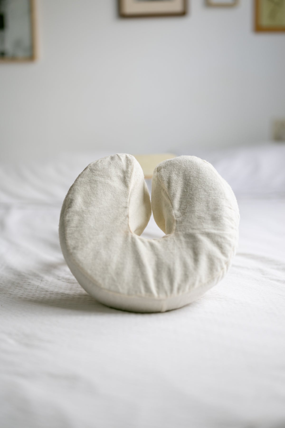 A almofada de cabeça com capa de algodão numa cama feita