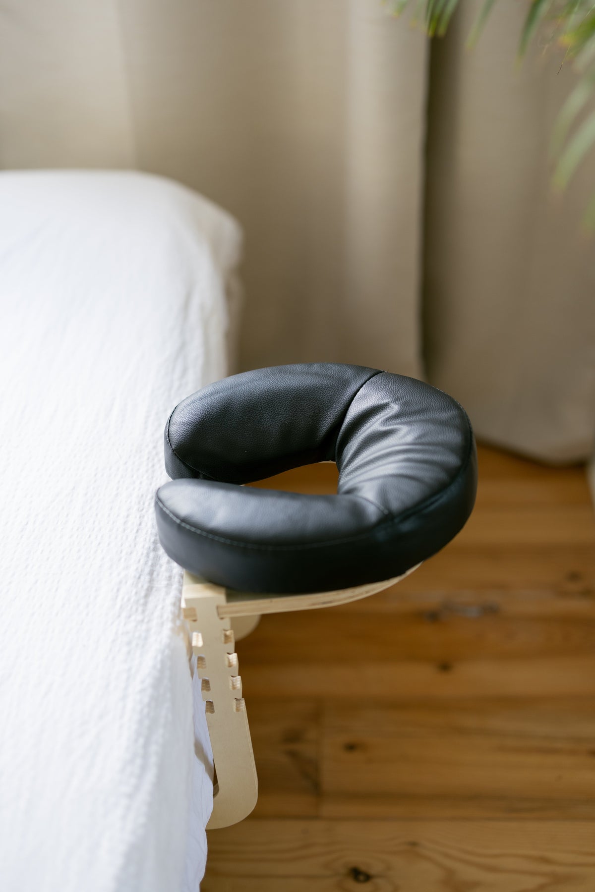 A almofada de cabeça preta na estrutura na borda de uma cama