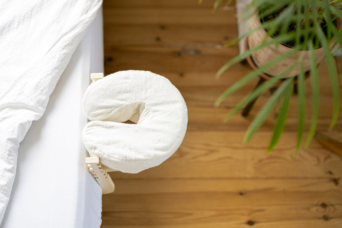 O Conjunto de massagem Ezspa na extremidade de uma cama feita, sobre um soalho de madeira