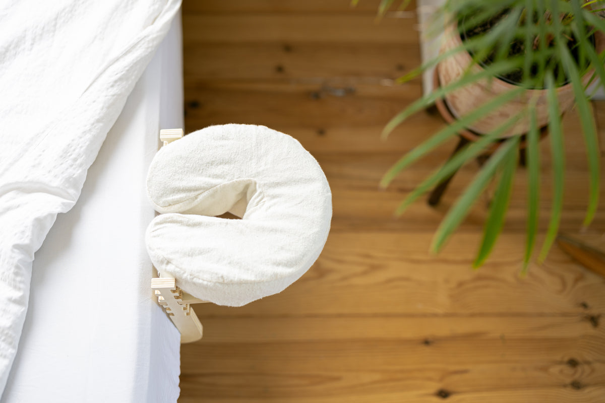 O Conjunto de massagem Ezspa na extremidade de uma cama feita, sobre um soalho de madeira